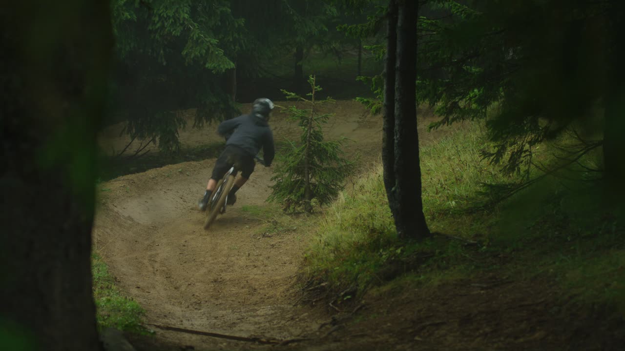 산악 자전거 타는 사람이 변덕스러운 숲에서 매우 빠르게 타고 있습니다.