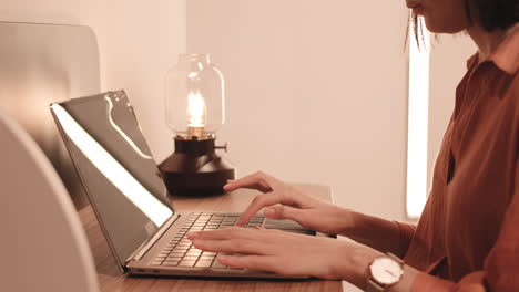person typing on computer by desk