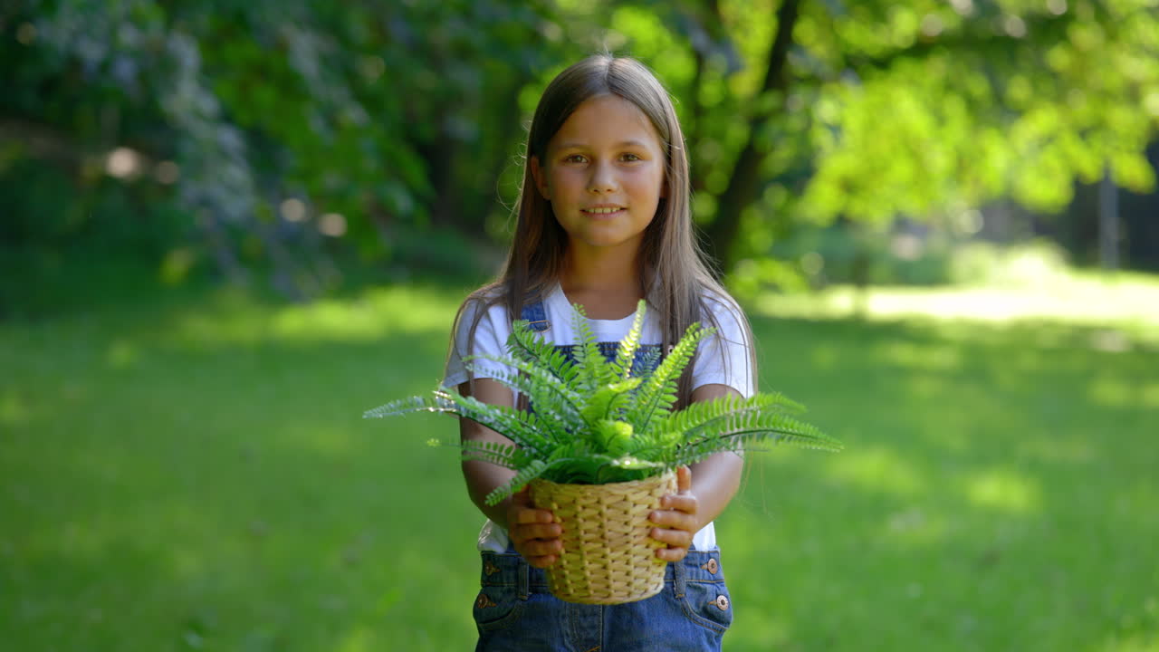 Girl Holding a Potted Plant in a Park