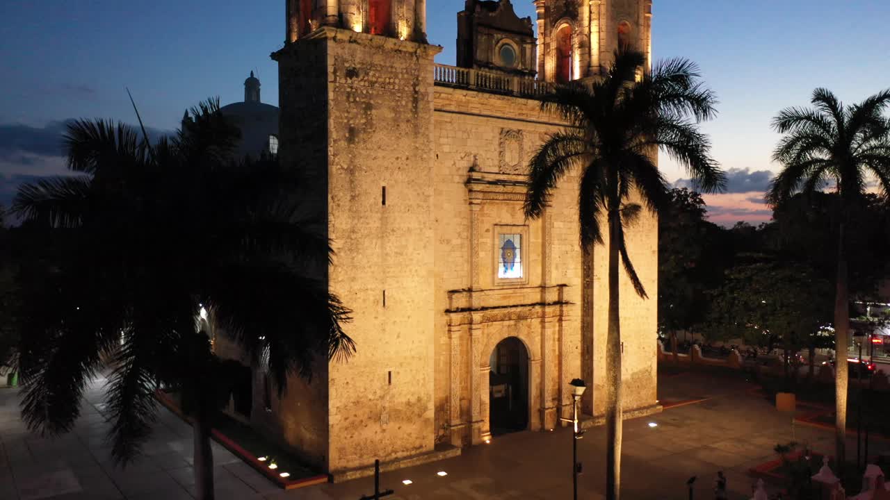 ascenso aéreo nocturno desde la esquina de la iglesia que muestra el primer plano de la catedral de san gervasio en valladolid, yucatán, méxico