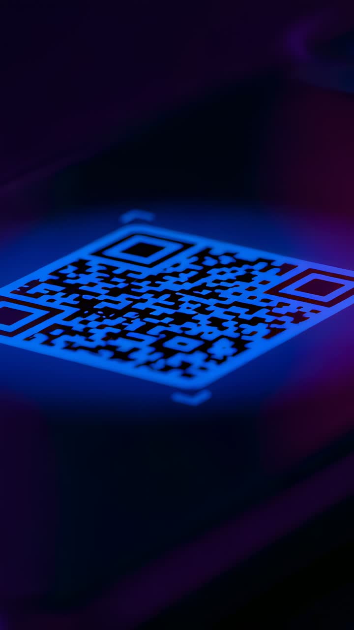 Vertical video: Moving camera revealing glowing QR code on dark pad, emphasizing neon rim, markers