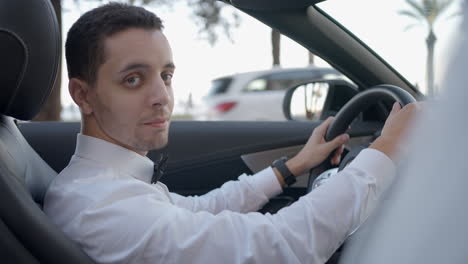 hombre conduciendo un descapotable de lujo