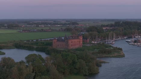 Wide-shot-of-castle-Muiderslot-at-Muiden-during-sunset,-aerial