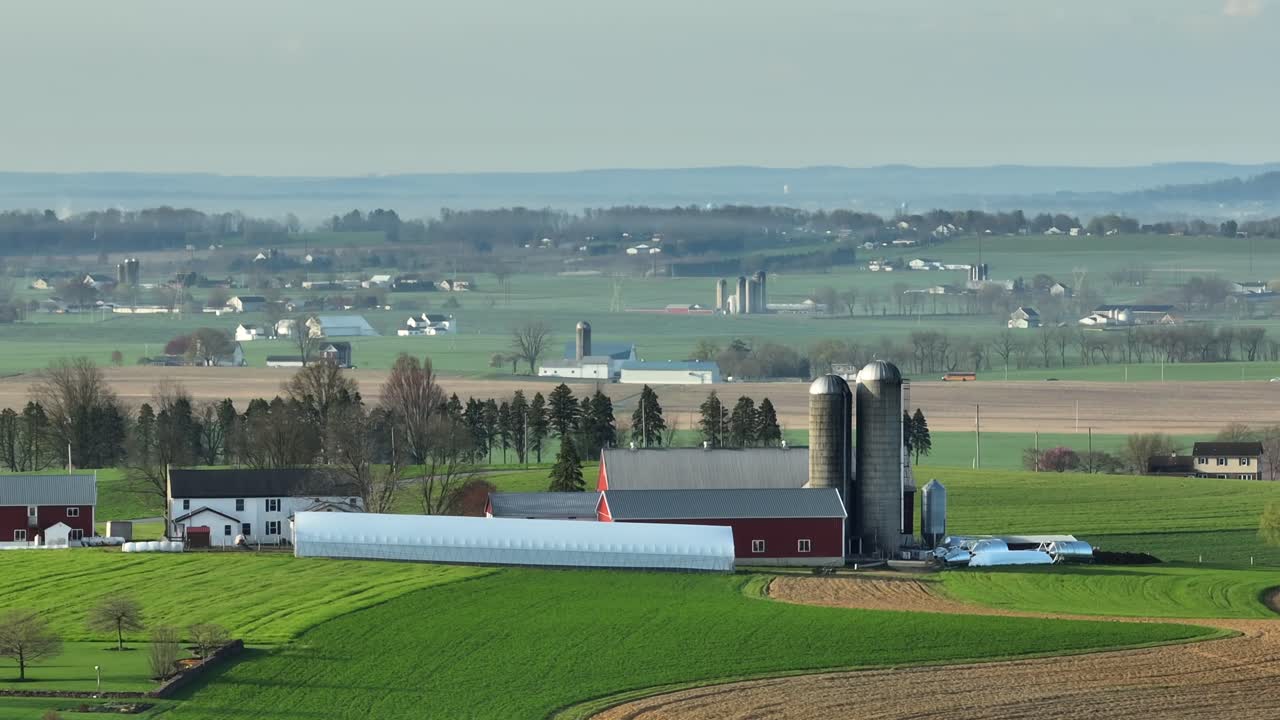 vista aérea de una granja con silo y establo en un campo idílico durante un día de niebla