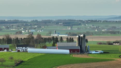 aerial view of farm house with silo and stable on idyllic countryside during foggy day