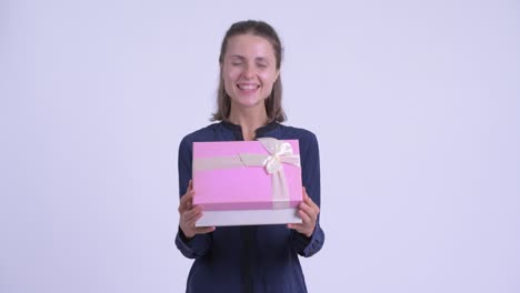 feliz joven hermosa mujer de negocios con caja de regalos