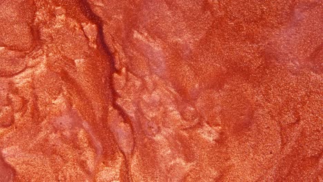 vista de cerca de un lápiz labial brillante y rojo bronce
