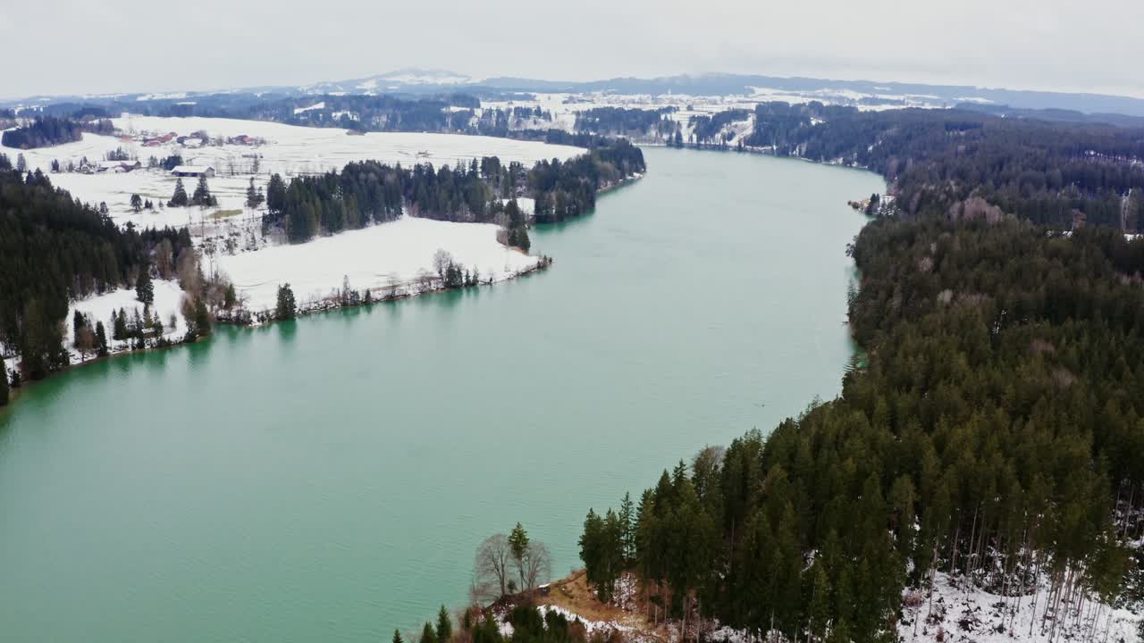 paisaje de invierno con lago turquesa y montañas nevadas