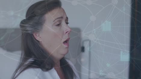 Animation-of-network-of-connections-with-icons-over-caucasian-senior-woman-sneezing