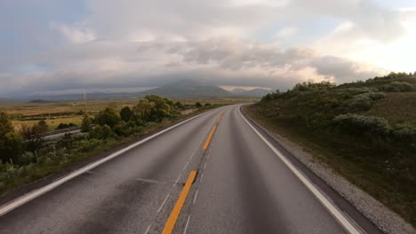um carro a conduzir numa estrada na noruega ao amanhecer