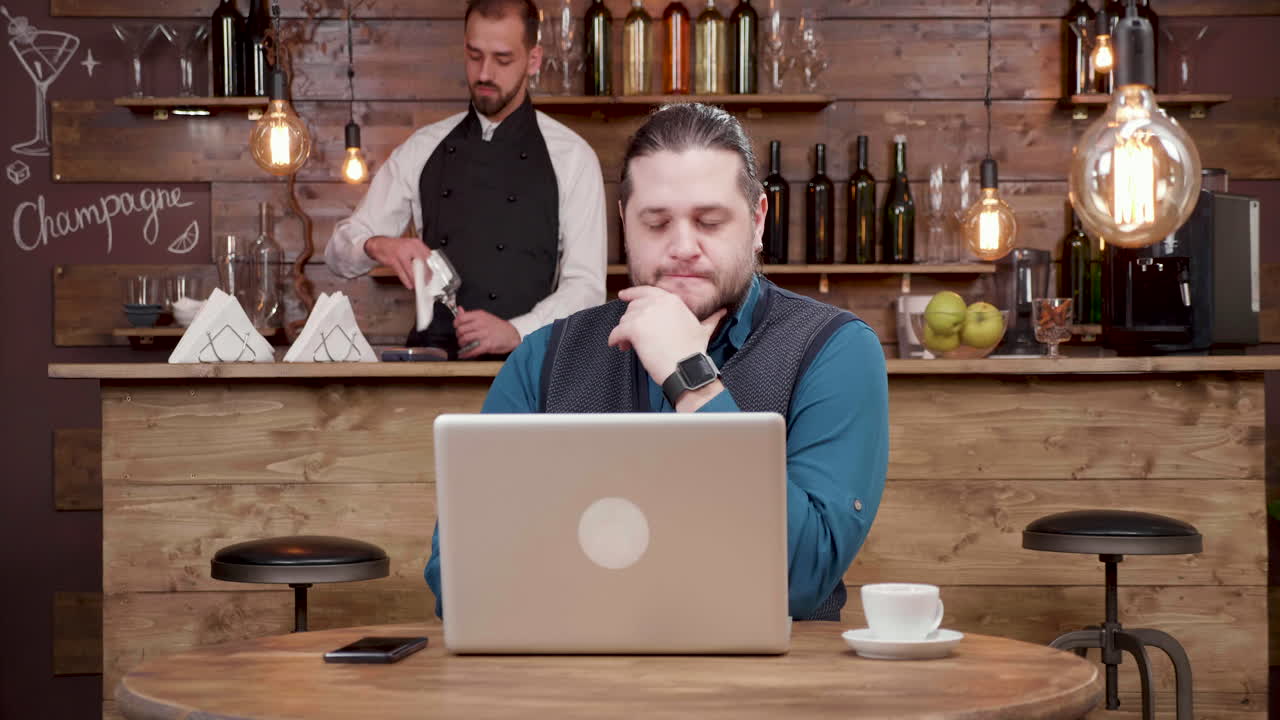 Man working on laptop in a bar