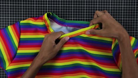 hombre latino diseñando una camiseta de colores arco iris