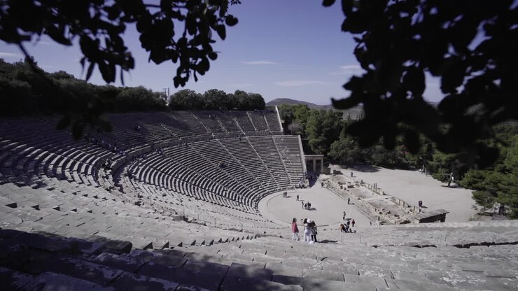 Tourists Visiting The Famous Ancient Theatre Of Epidaurus On The West Side Of Cynortion Mountain On A Sunny Day In Greece. - pan down