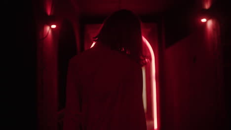 woman walking through a neon red archway