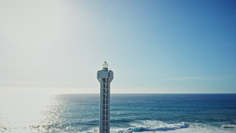 drone aéreo disparado alrededor de un faro ubicado en la costa de la palma, islas canarias, españa. vista alta de las olas que llegan a la costa.