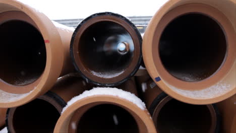 snow is falling in winter time, as we look inside some long brown pipes