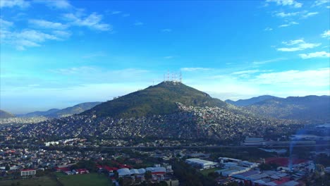 hill surrounded by constructions antennas on top