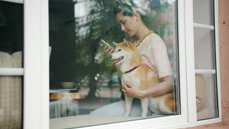 woman with shiba inu dog at a window seat