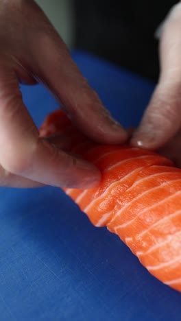 sushi chef making salmon sushi roll