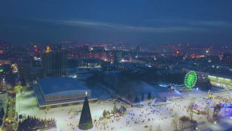 winter fair with xmas tree and ferris wheel aerial view