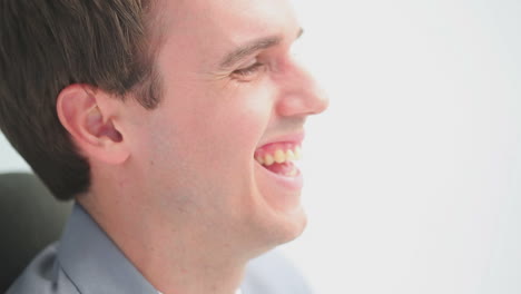 hombre feliz riendo mientras está sentado en una silla