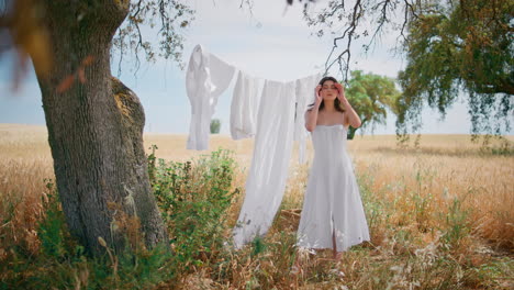 rural woman drying laundry at wild nature garden. summer girl posing rye field