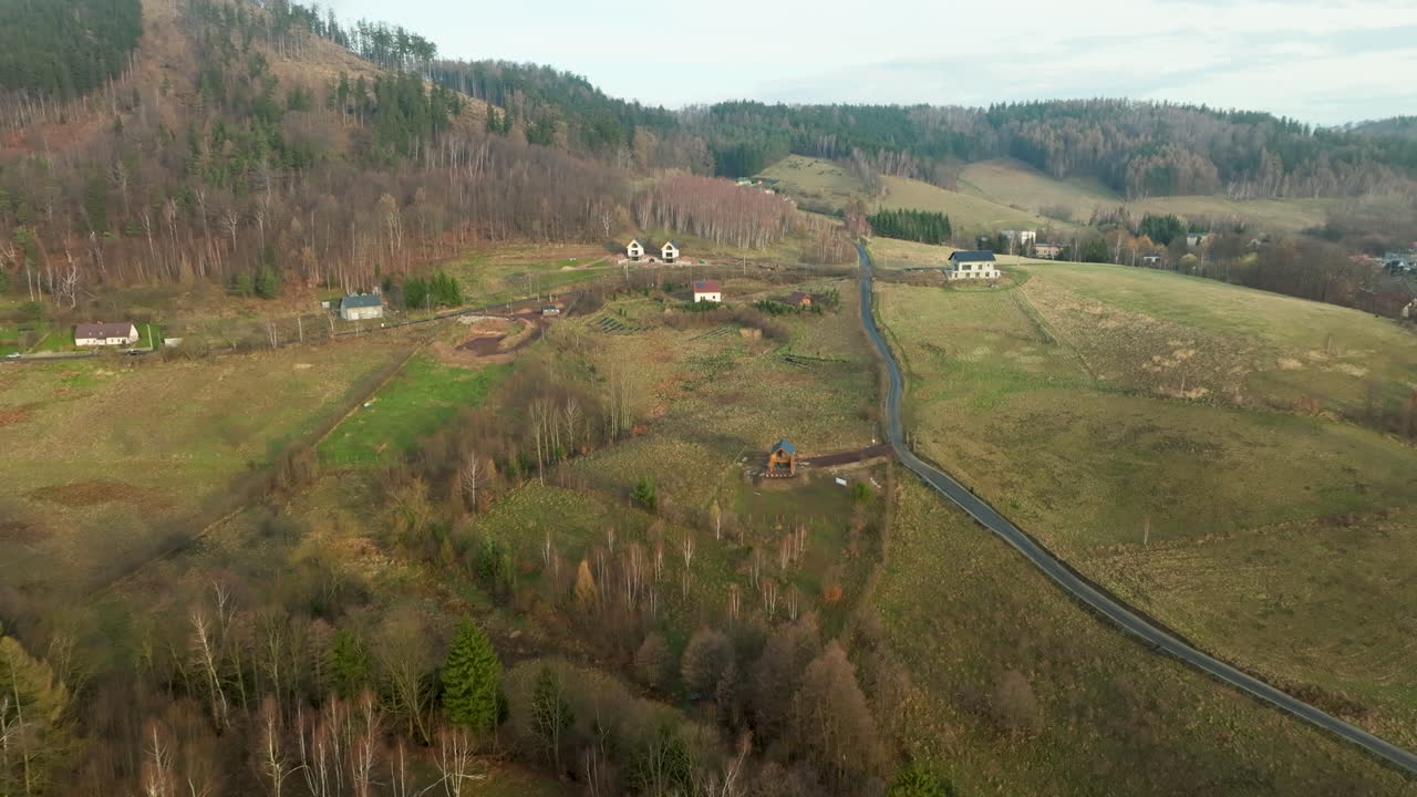 paisaje montañoso con casas esparcidas y un camino sinuoso