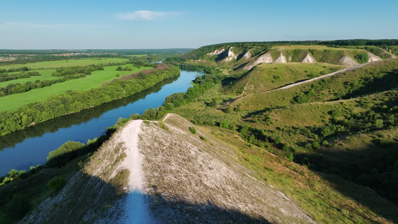 Vista Aerea di una Valle Fluviale con Colline e un Sentiero