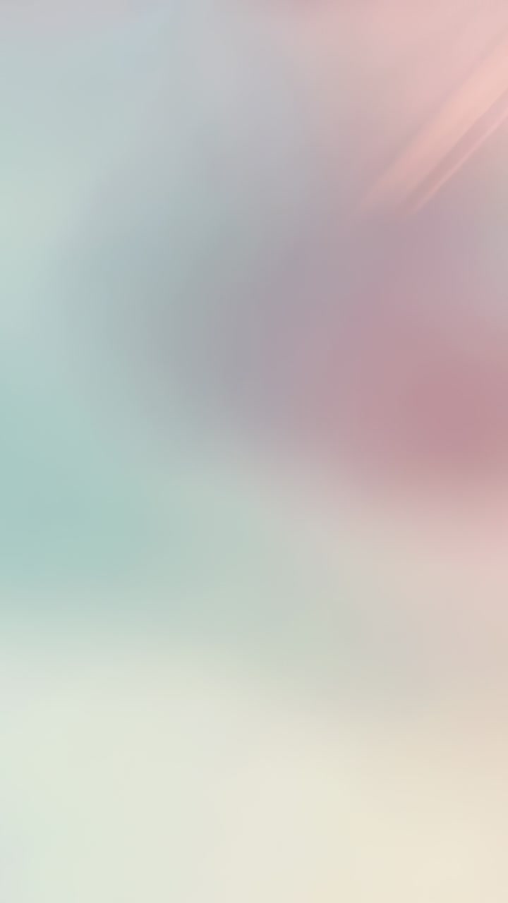 Vertical video: Playing pastel blur cycling in loop, showing teal aqua pink streaks as background
