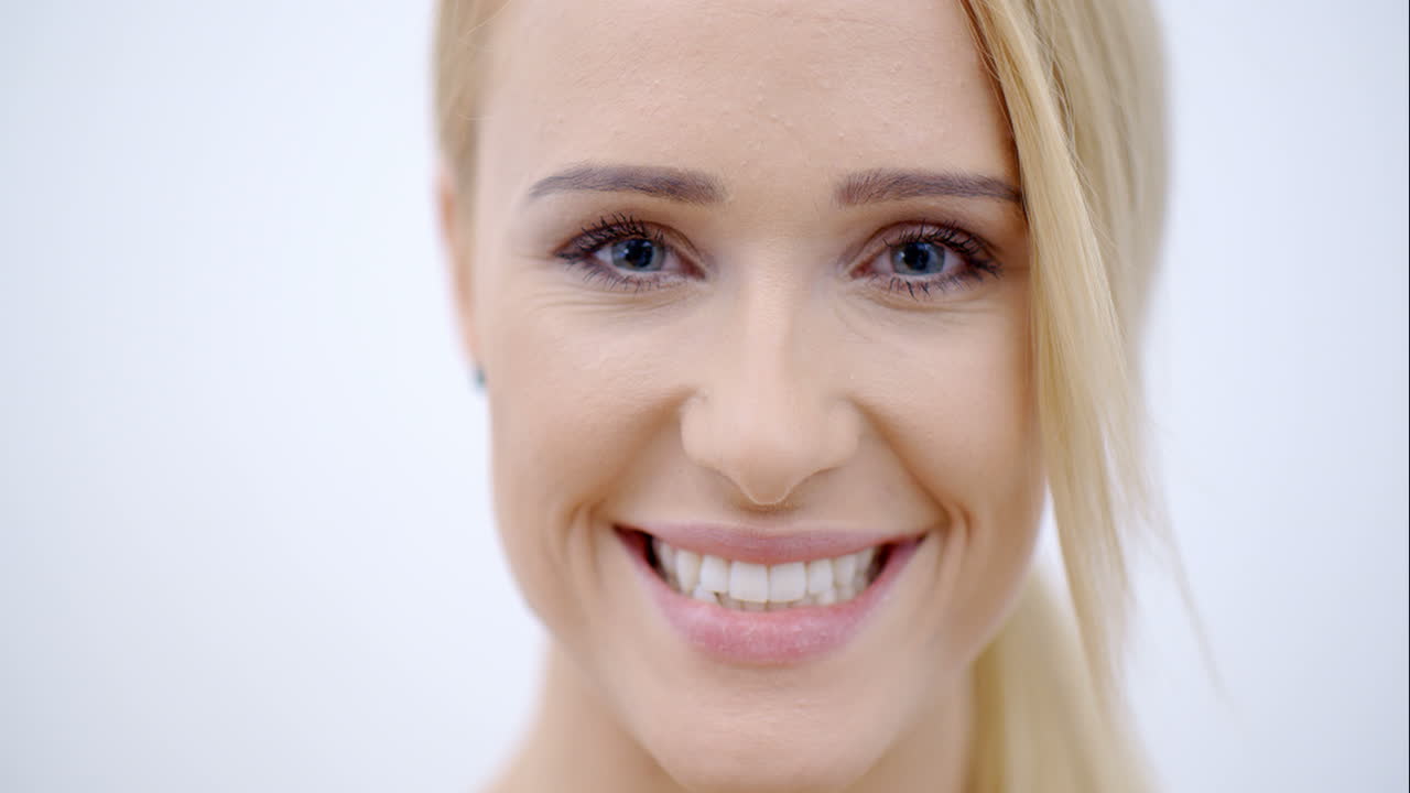 cerca de la cara sonriente de una mujer bonita y rubia