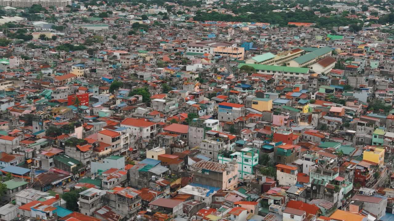 An aerial shot showcasing a densely populated squatter settlement in the Philippines. A vibrant yet challenging urban landscape, with tightly packed makeshift homes and narrow streets