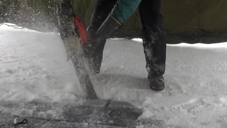 Cutting-thick-lake-ice-with-a-chainsaw