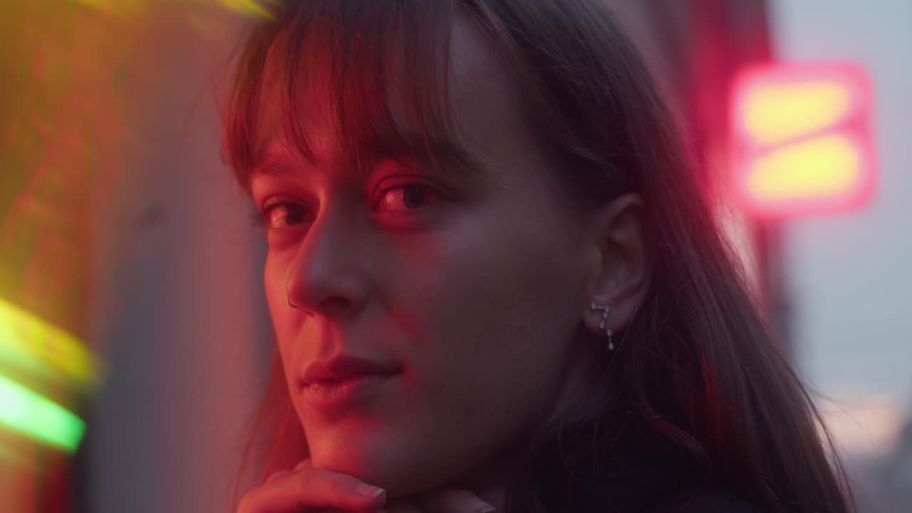young woman, girl, staring into lens, gazing, red light, blurry lights, dawn, pretty mysterious look, earring, beautiful face, cinematic close-up shot.