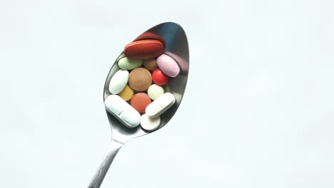 high angle view of pills on spoon on white background ,