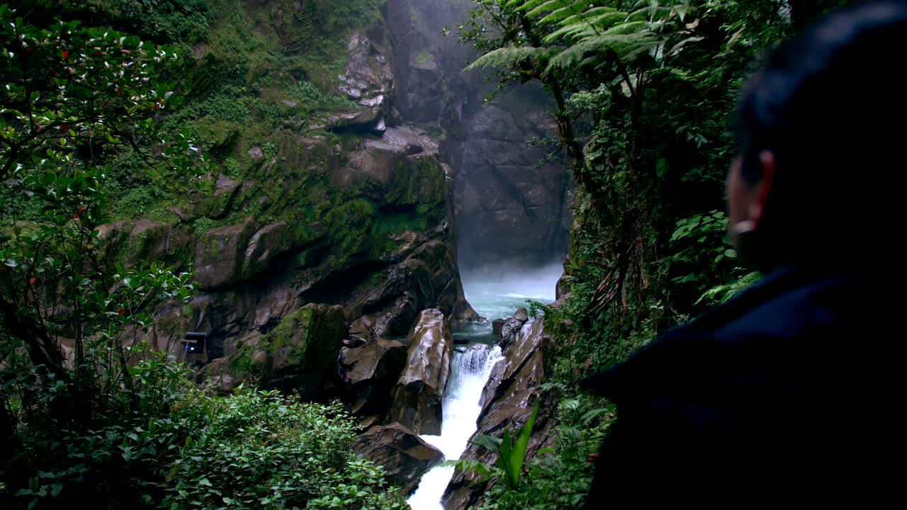 Back woman watching water effects with evanescent mist of the waterfall Devil's Cauldron