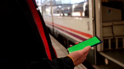 close up of man using smartphone with green screen