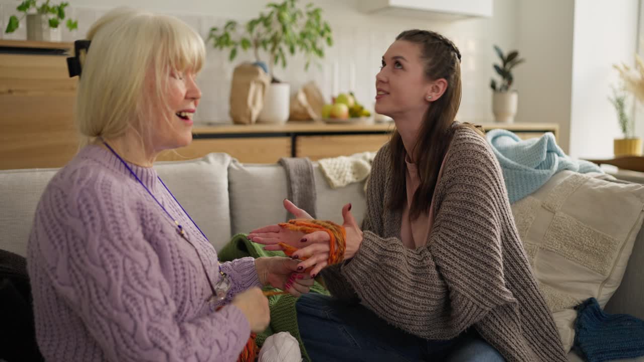 손녀와 할머니가 함께 뜨개질을 합니다.