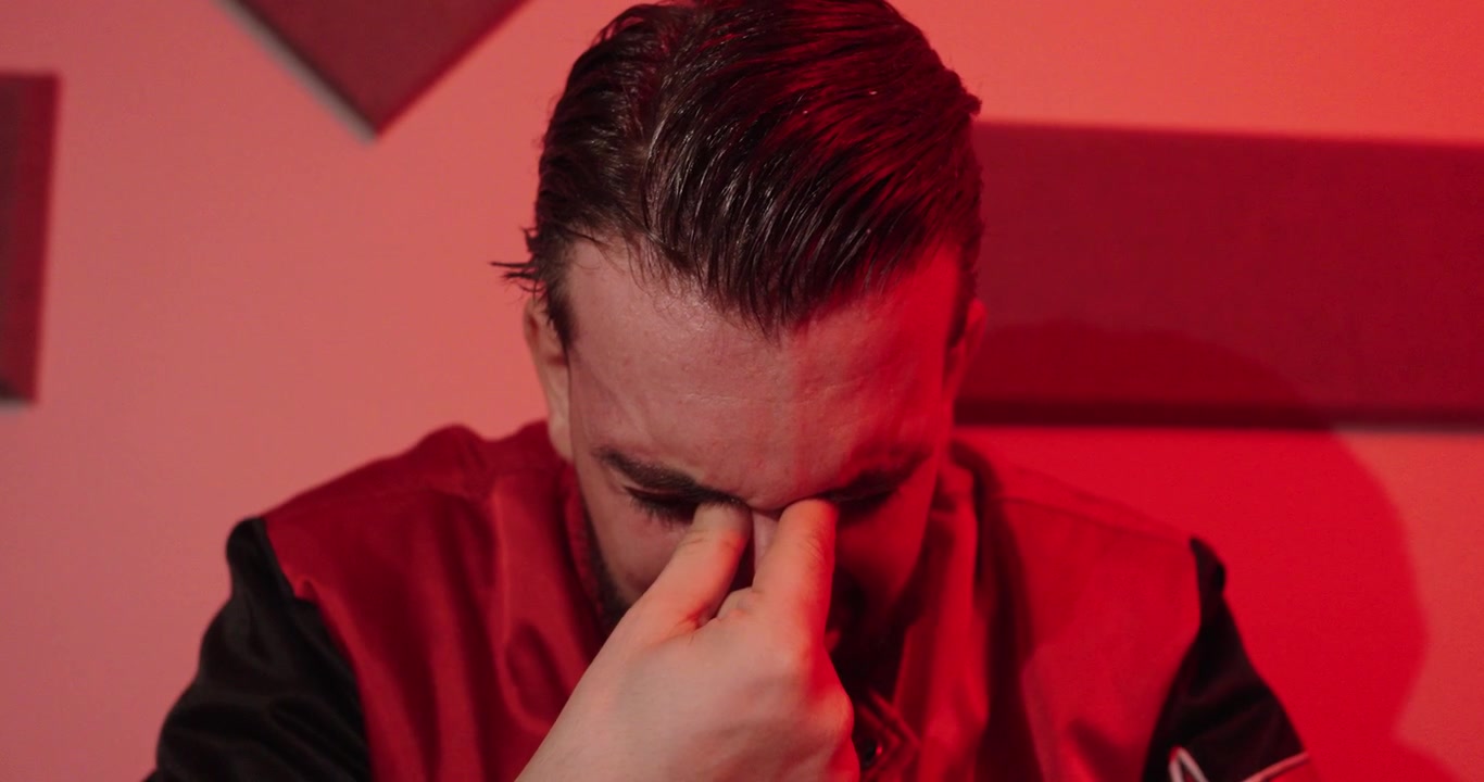 Primo piano di un uomo stressato che si strofina gli occhi e il viso, rappresentando esaurimento emotivo, tristezza, frustrazione, affaticamento e stress mentale.