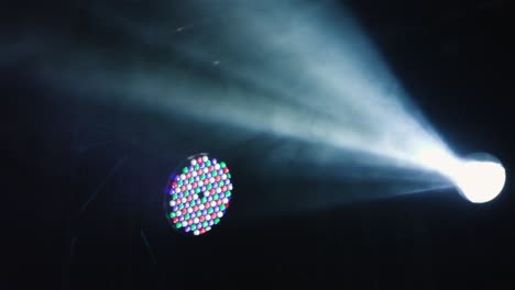 micrófono en el escenario con humo azul y luz detrás de él. plano cercano de ángulo bajo de mano