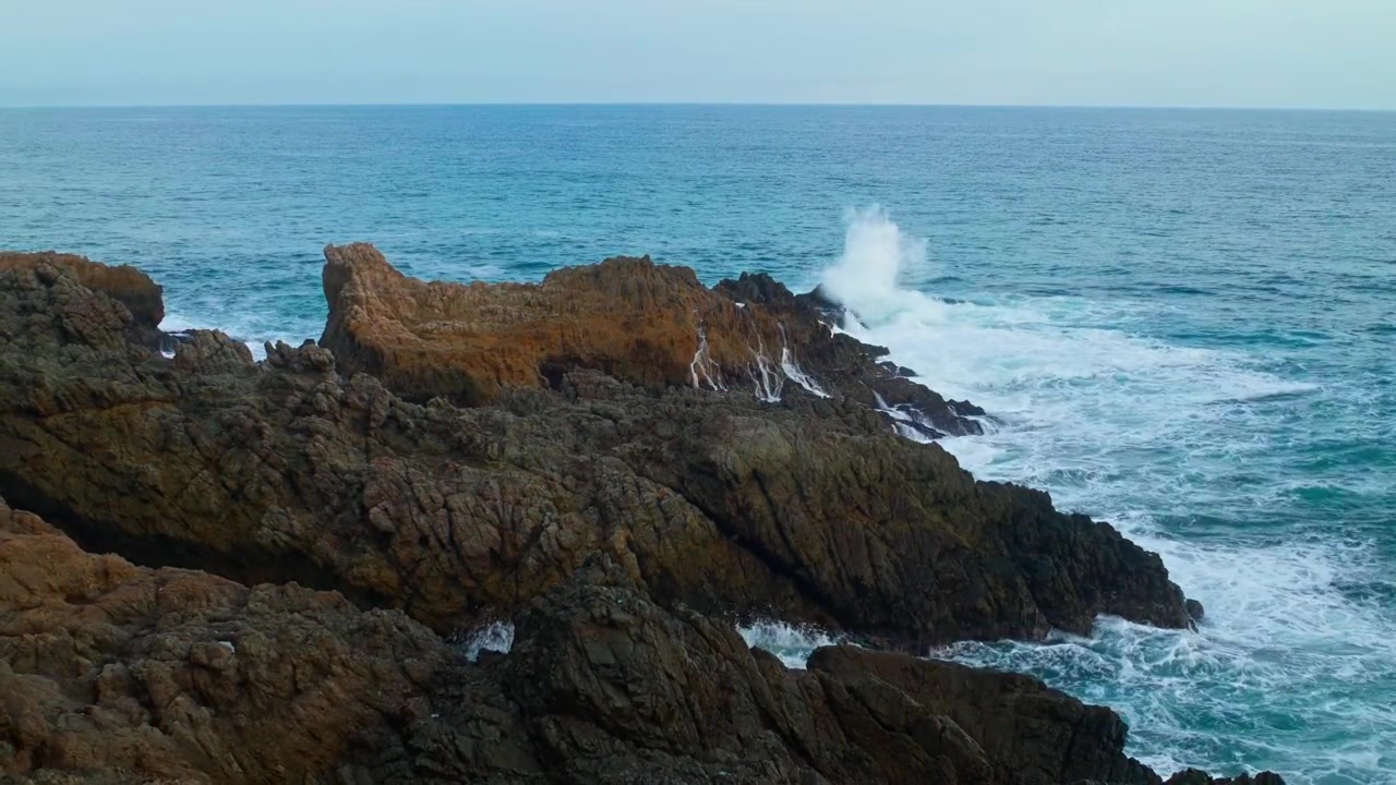 La spuma bianca si riversa sulle rocce costiere frastagliate a Bejuco Beach, sulla costa pacifica della Costa Rica, creando una schiuma bianca rilassante e pacifica.