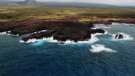 dark lava rock meets the crashing waves on the big island of hawaii