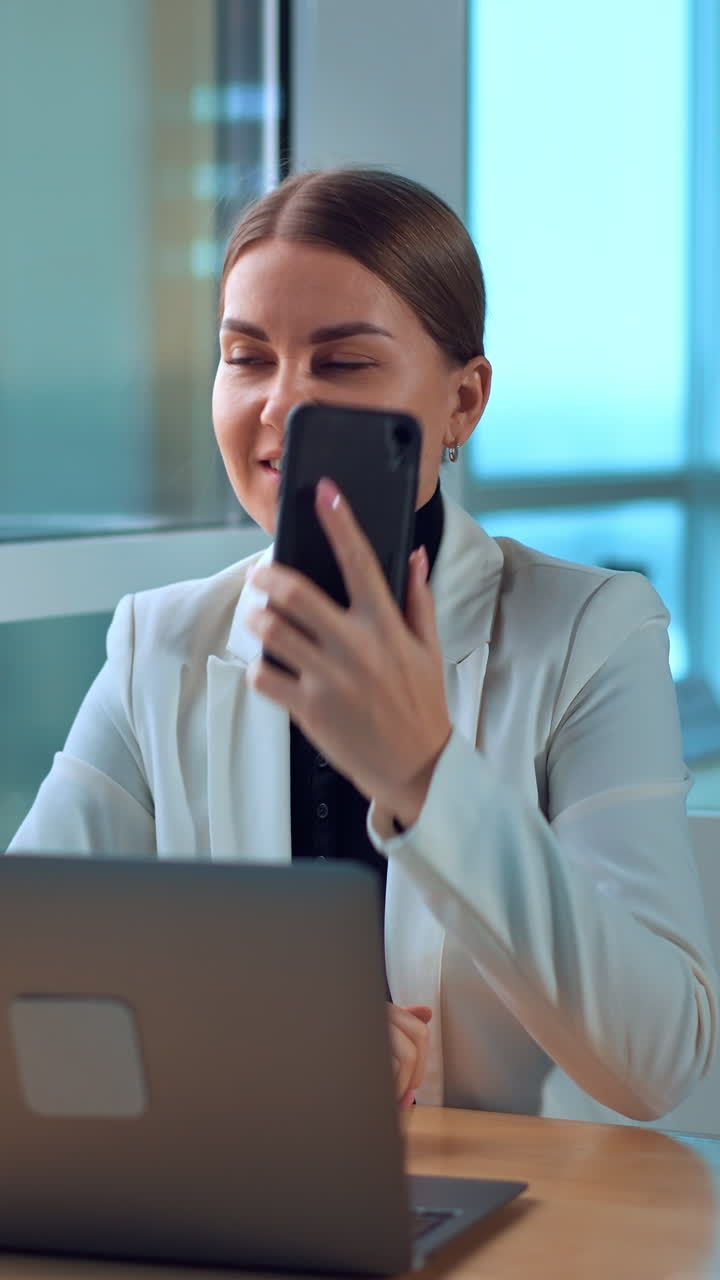 Business woman with laptop working in modern office. Young pretty manager using computer. Vertical video