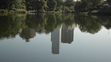 edificios de gran altura reflejados en un estanque en el parque de la ciudad-2