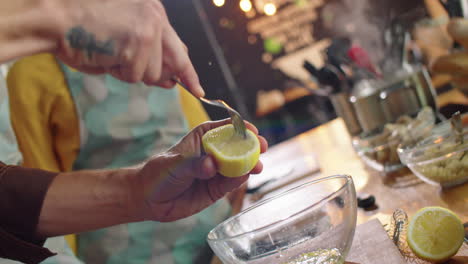 hand of male chef squeezing lemon juice