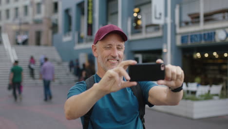 Porträt-Eines-Reifen,-Attraktiven-Kaukasischen-Touristenmannes-Mit-Hut-Und-Smartphone,-Der-Fotos-Von-Besichtigungen-Macht