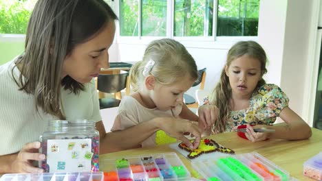 mother and daughters making pixel art with beads