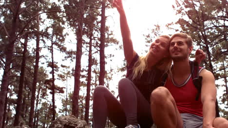 una pareja tomando un descanso después de una caminata cuesta arriba.