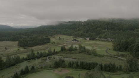 Drone-Volando-A-Través-De-Un-Hermoso-Paisaje-Neblinoso-En-La-Cima-De-Una-Montaña,-Sobre-Un-Campo-De-Golf-1