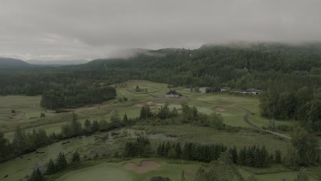 drone flying through a beautiful foggy mountain top landscape, over a golf course-1