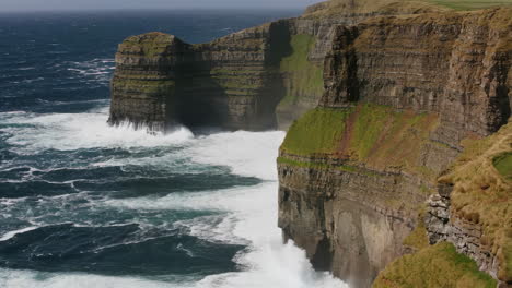 dramatic waves crashing against the cliffs of moher, ireland